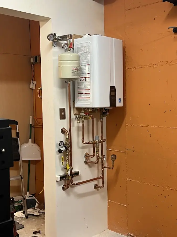 Plumbing technician inspecting water heater connections in Pearsall